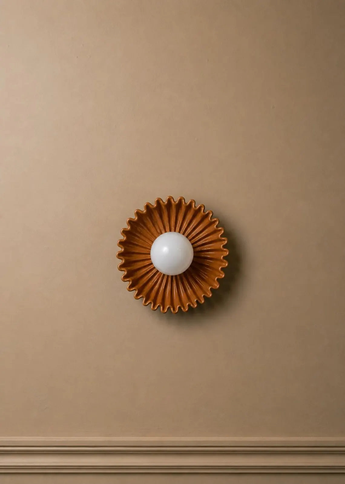The Solara ceramic sunburst wall sconce with opal glass globe