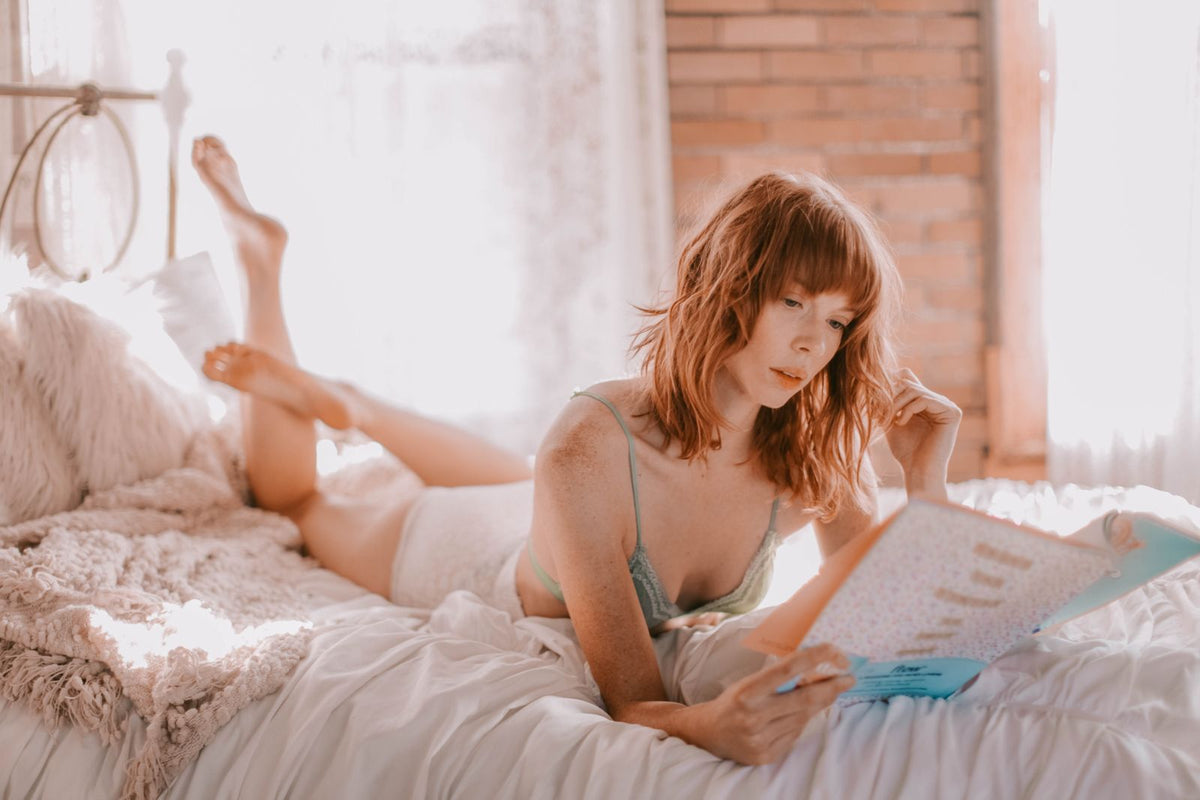 Woman reading a book in bed by soft light
