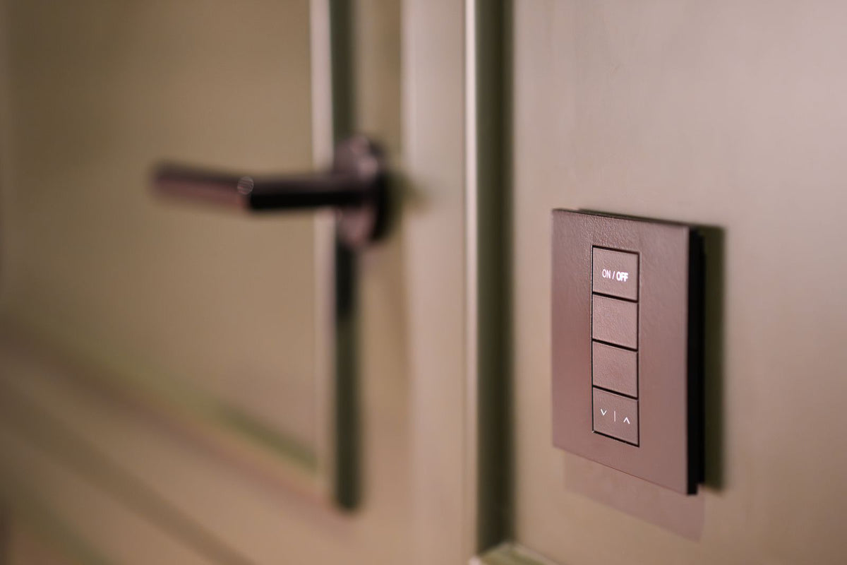 Slim smart light switch panel mounted beside a doorway