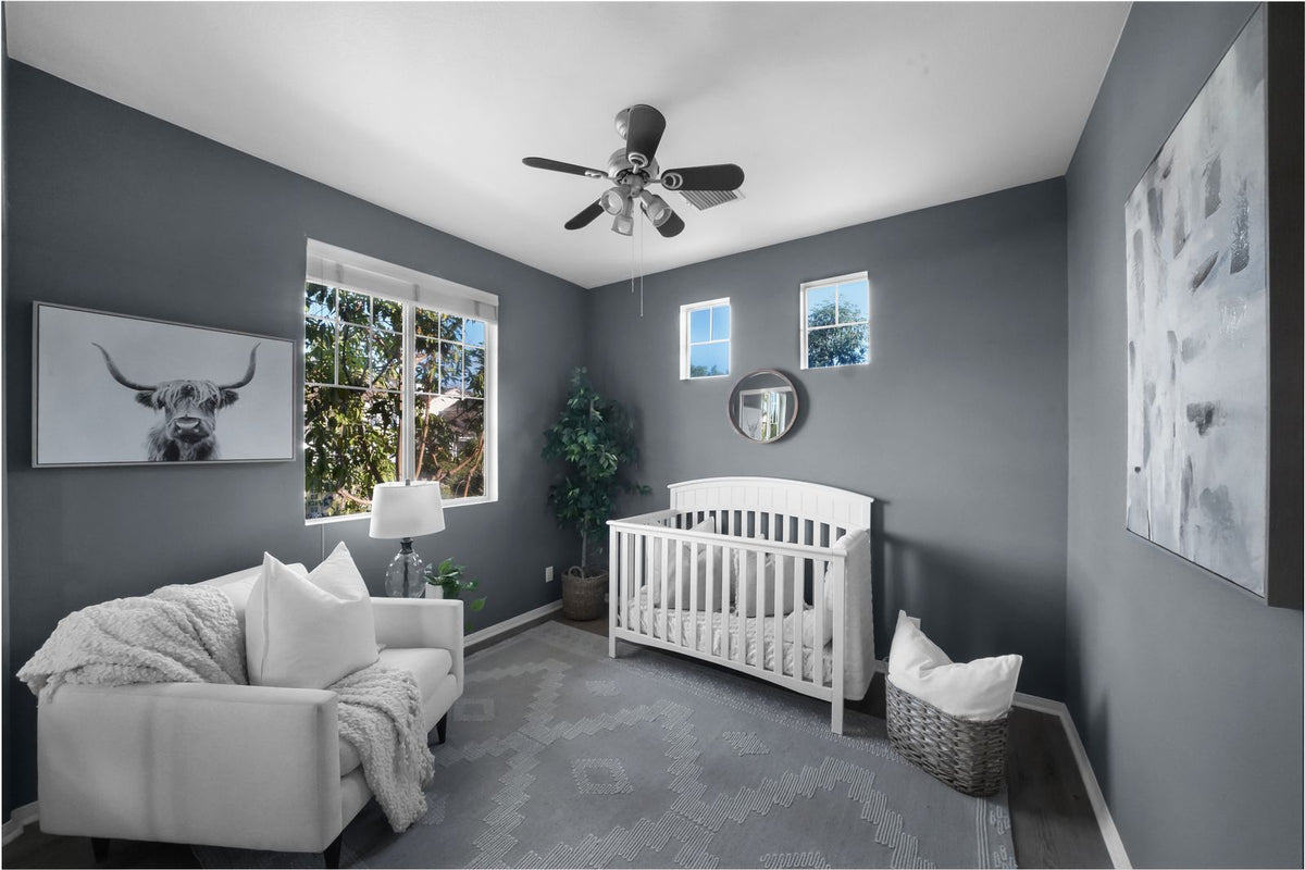 Calm grey nursery with a white cot and soft natural light