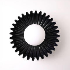 The Solara black ceramic sunburst wall sconce