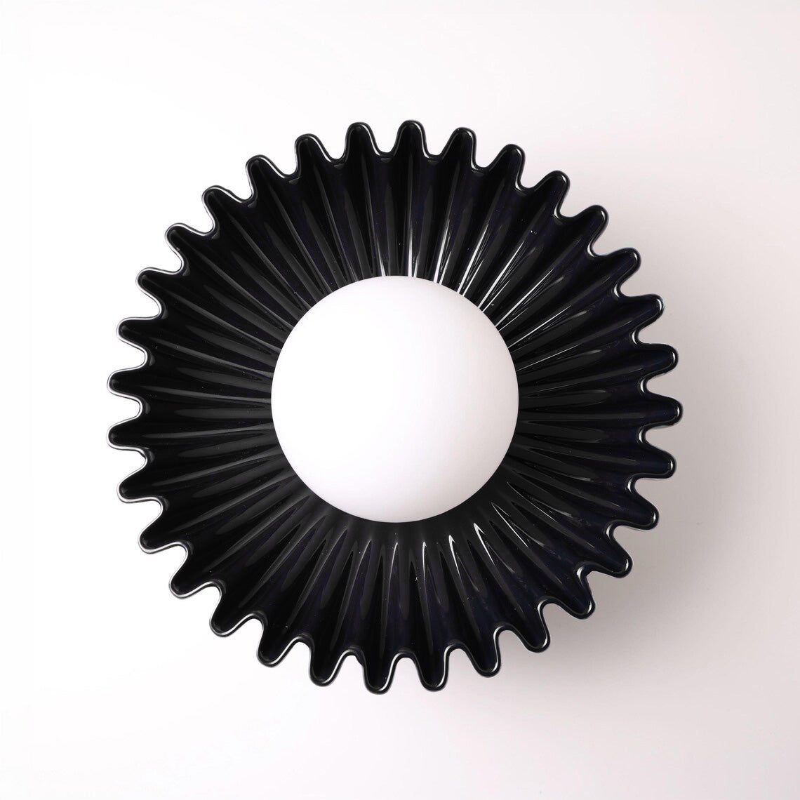 The Solara black ceramic sunburst wall sconce