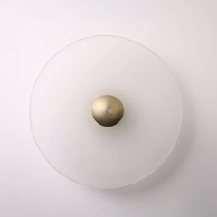 The Orbis wall sconce in bronze, lit with warm LED halo