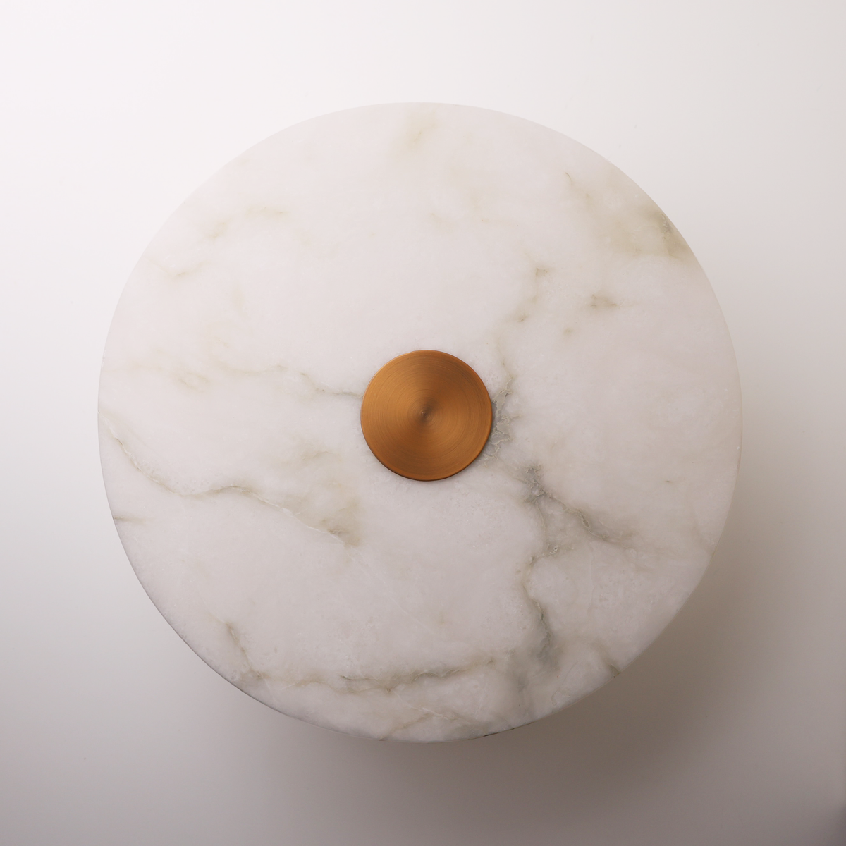 The Alba natural alabaster disc wall light with brushed brass, front view