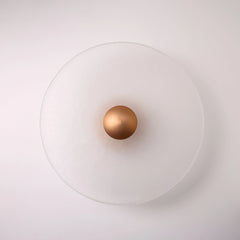 The Orbis wall sconce in copper, lit with warm LED halo