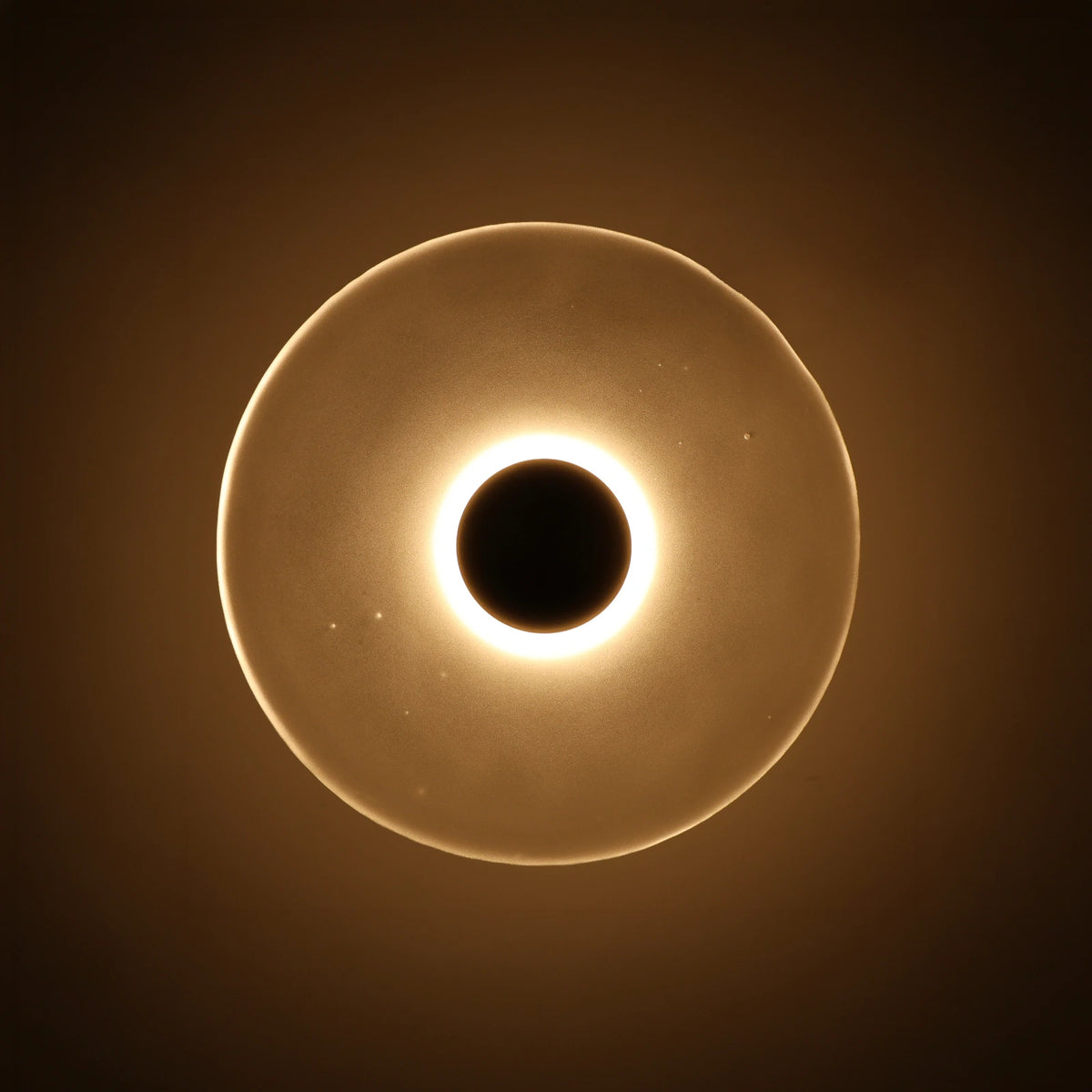 The Orbis wall sconce glowing at night, nickel finish