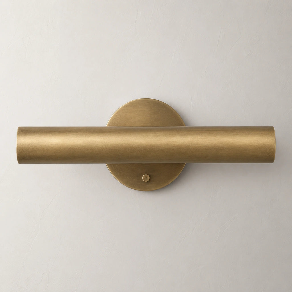 The Aurum brass wall sconce lit with warm white glow