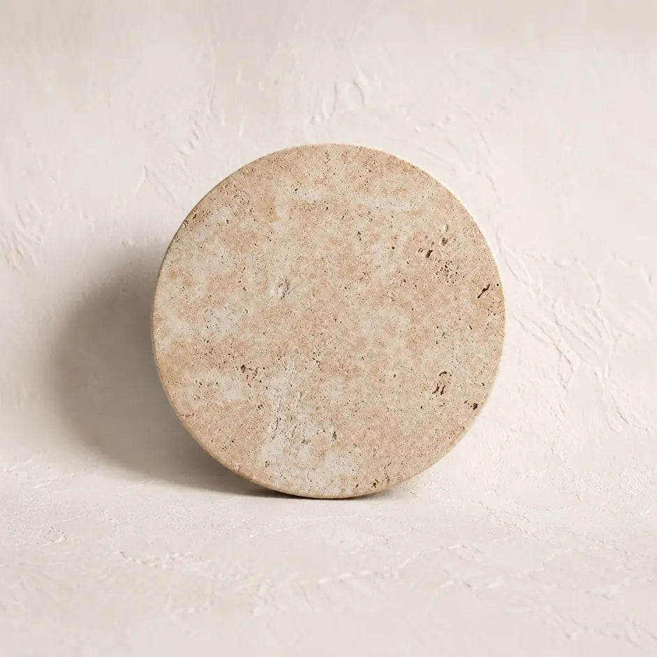 The Terra stone wall sconce lit with warm glow
