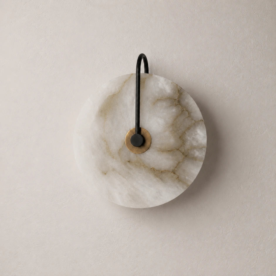 The Marquise marble stone wall sconce lit with warm white light