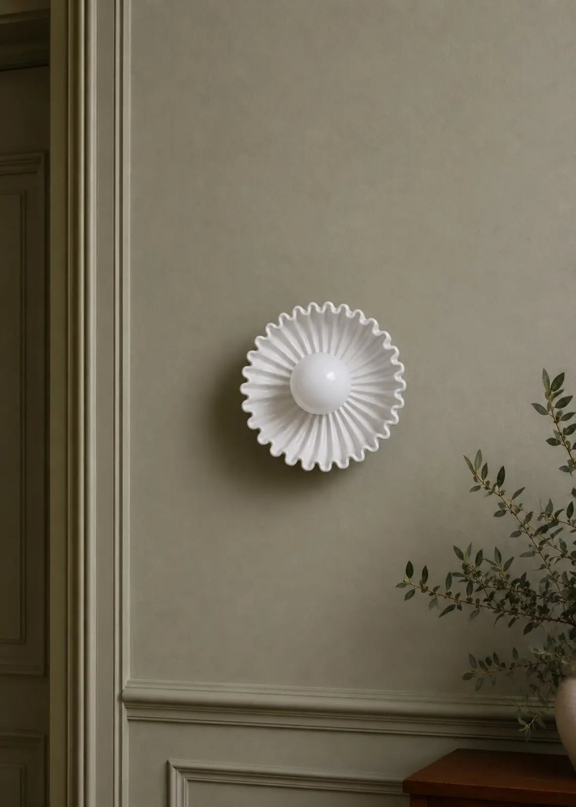 The Solara white ceramic sunburst wall sconce in living room