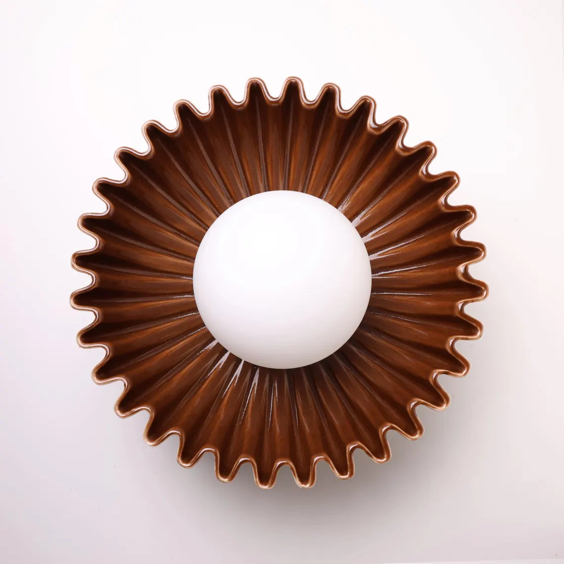 The Solara ceramic sunburst wall sconce in brown, front view