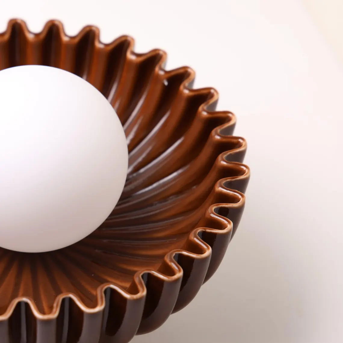 The Solara brown ceramic sunburst sconce side view