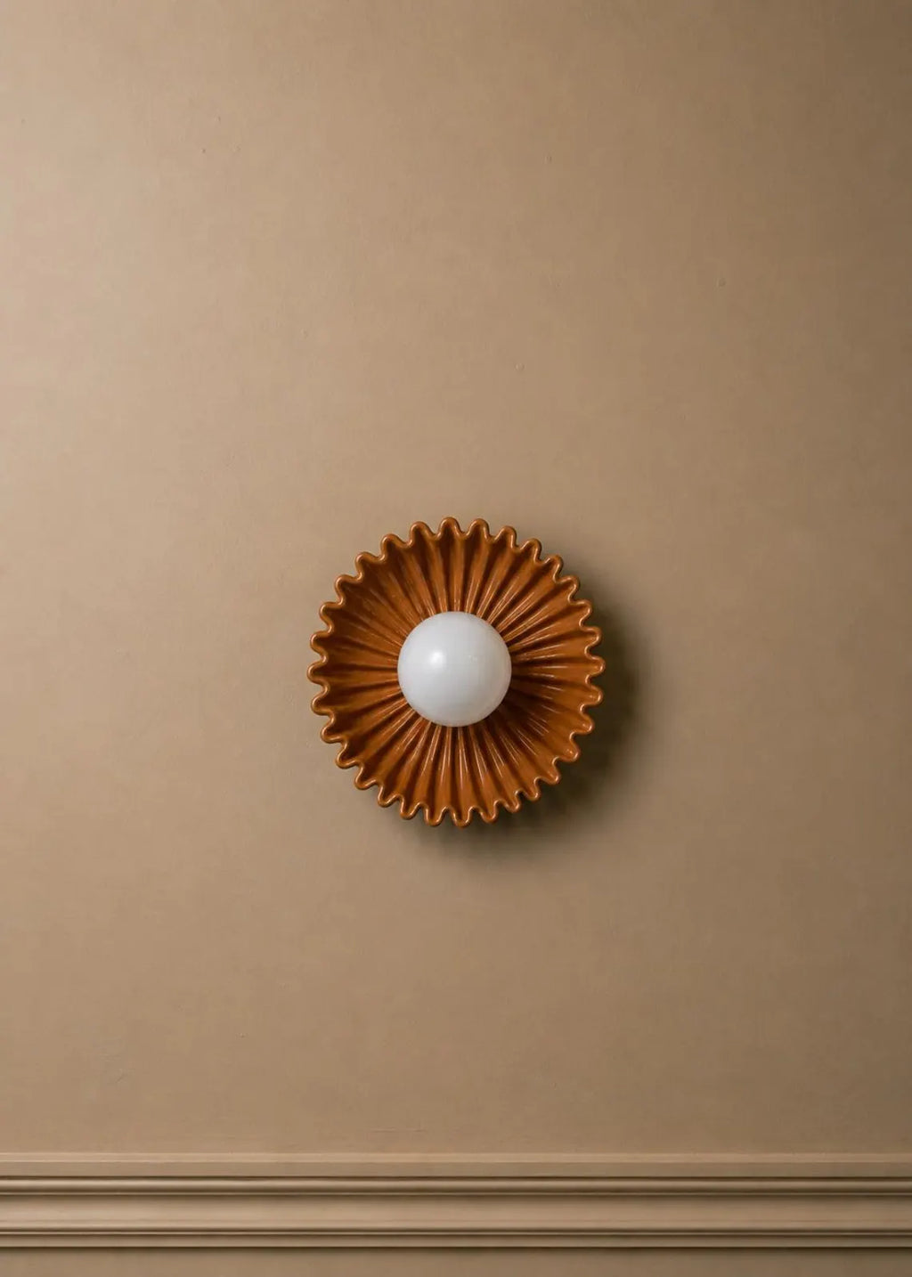The Solara ceramic sunburst wall sconce with opal glass globe