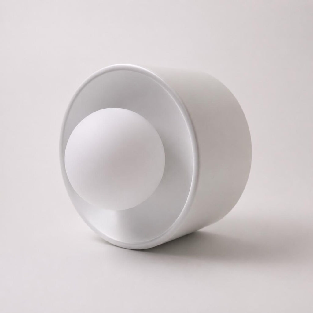 The Volta ceramic wall sconce glowing warm white